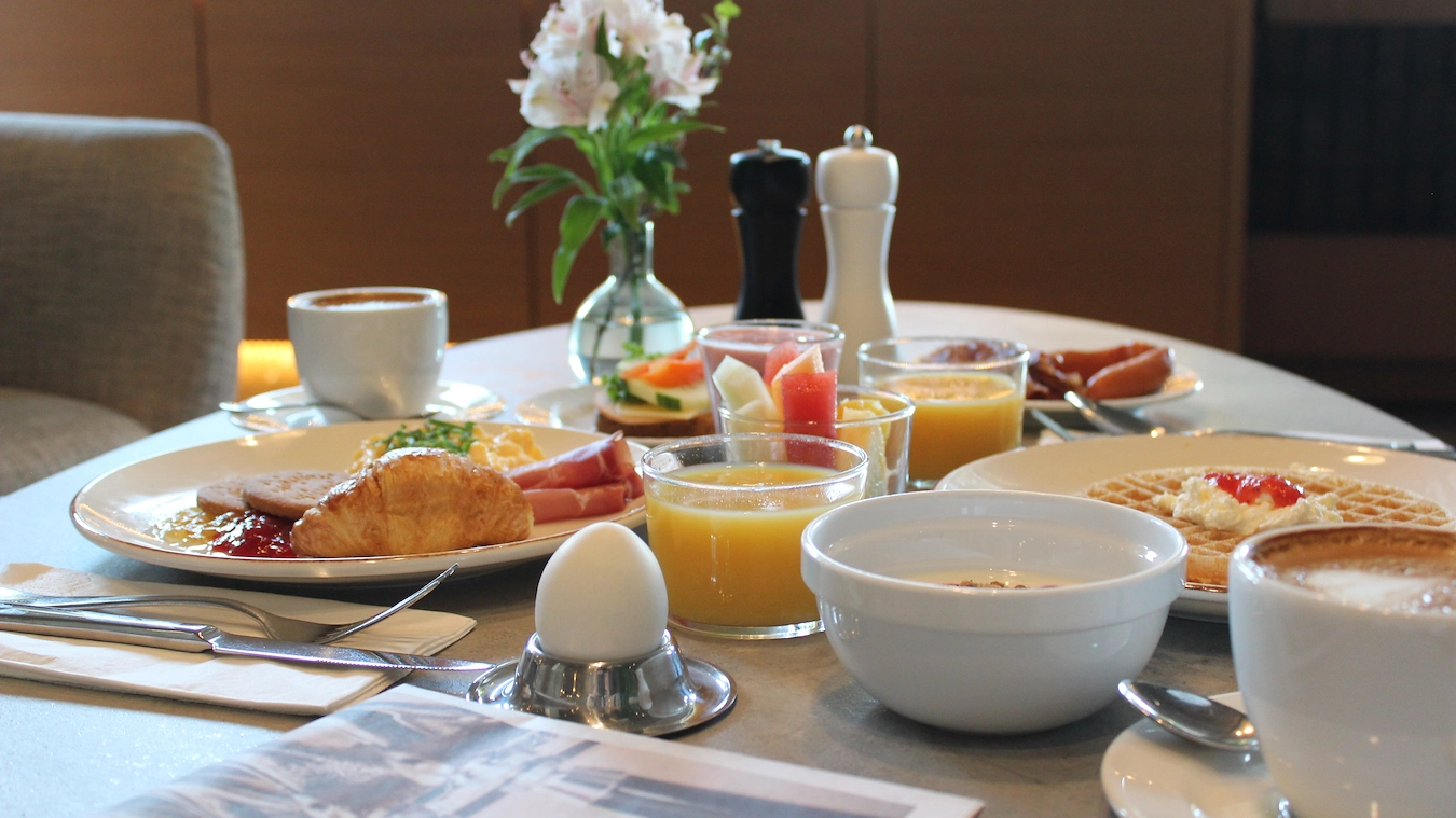 Varierad hotellfrukost med frukt, bröd och pålägg i Bromma